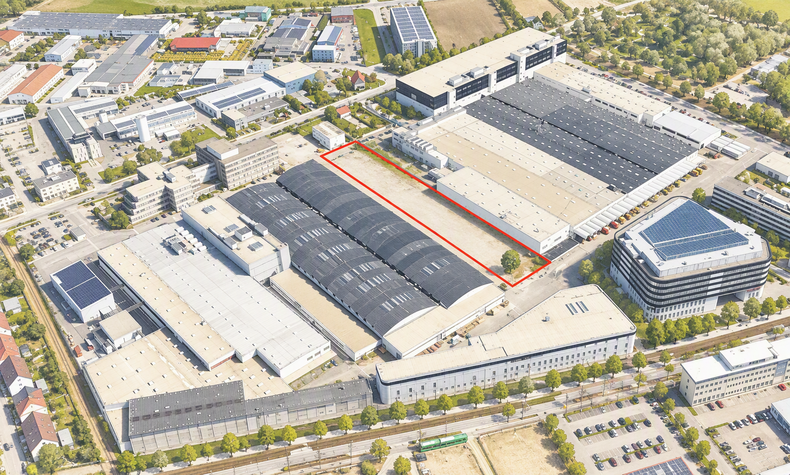 Aerialaufnahme eines Industrie- und Werksgeländes mit langgezogenem, rot markiertem Hallenbereich innerhalb eines großen Produktionskomplexes