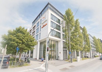 Modernes Bürogebäude mit Glasfassade in München an einer Straßenkreuzung
