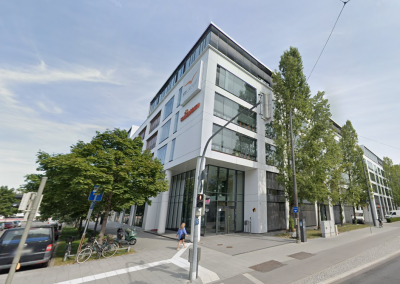 Modernes Bürogebäude mit Glasfassade in München an einer Straßenkreuzung