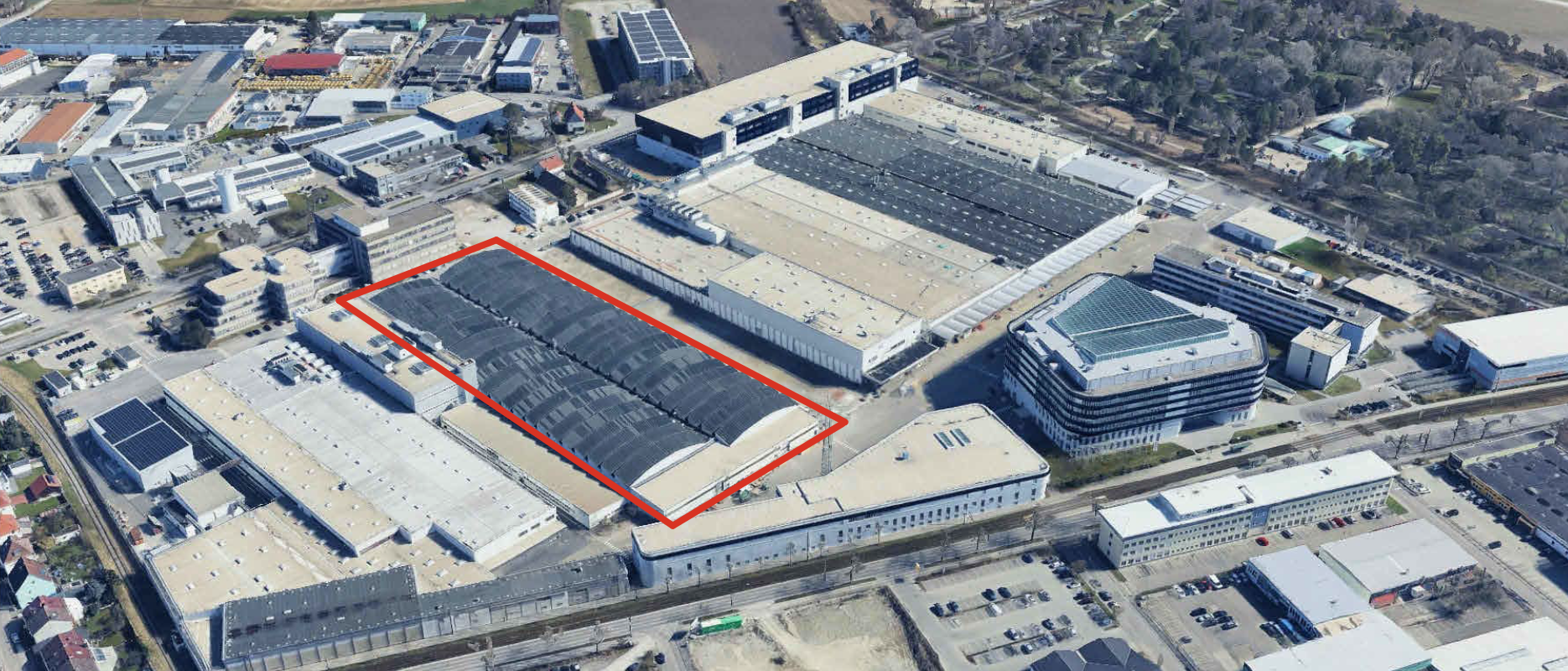 Aerialaufnahme eines Industrie- und Werksgeländes mit markiertem Gebäudebereich innerhalb eines großen Produktionskomplexes