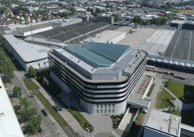Aerialaufnahme eines modernen Büro- und Verwaltungsgebäudes innerhalb eines großen Industrie- und Werksgeländes